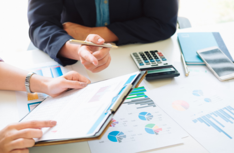 business man and women looking at balance sheets and financial documents