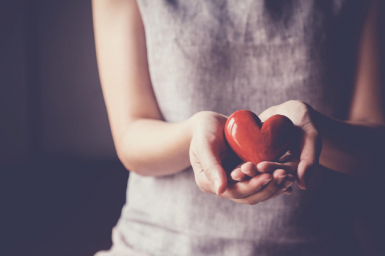 woman holding ceramic red heart in hands