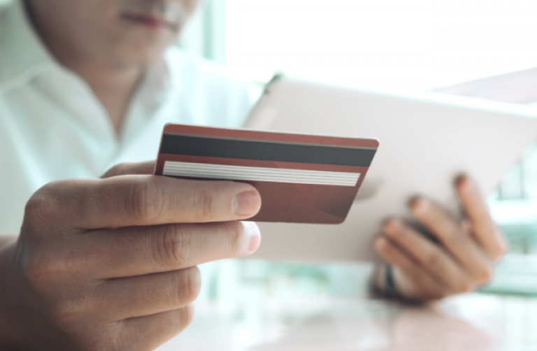 man holding ipad and credit card to make an online donation